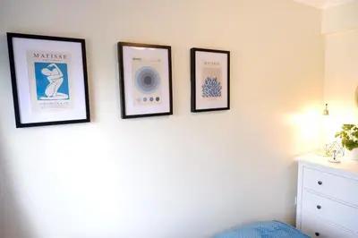 three framed pictures on a wall with a radio at Modern 2-Bed Duplex - 10 Mins to City Centre in Chesterton