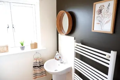 a bathroom with a white sink and a mirror at Modern 2-Bed Duplex - 10 Mins to City Centre in Chesterton