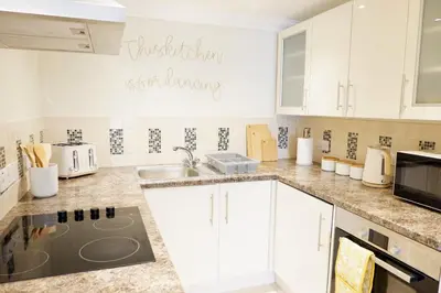 a kitchen with white cabinets and a sink at Modern 2-Bed Duplex - 10 Mins to City Centre in Chesterton