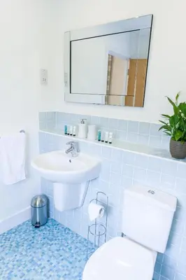 a bathroom with a sink and a toilet and a mirror at Camstay Longworth Avenue in Cambridge
