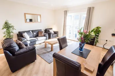 a living room with a table and a couch at Camstay Longworth Avenue in Cambridge
