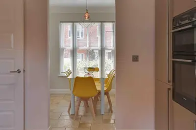 a kitchen with a table and chairs and a window at Elizabeth II Five Bedroom Spacious Home in Bocking Churchstreet