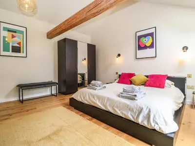 a bedroom with a large white bed with red pillows at The Cart Lodge at Grove Barn in Eye