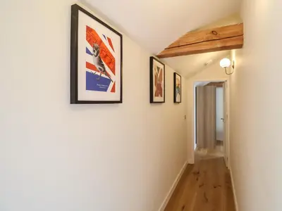 a hallway with three framed pictures on the wall at The Cart Lodge at Grove Barn in Eye