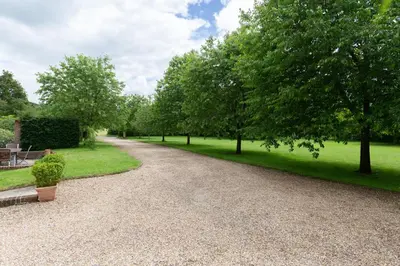 a gravel driveway with trees in a park at The Cart Lodge at Grove Barn in Eye