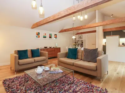 a living room with two couches and a table at The Cart Lodge at Grove Barn in Eye