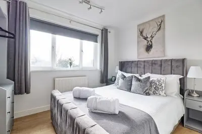 a bedroom with a large bed and a couch at Lavish Rayleigh Apartment - LMV Property in Rayleigh