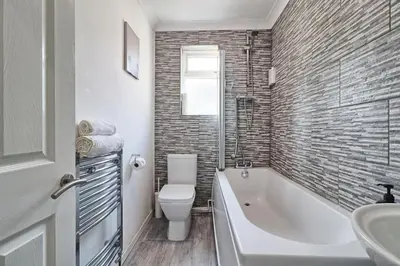 a bathroom with a tub and a toilet and a sink at Lavish Rayleigh Apartment - LMV Property in Rayleigh