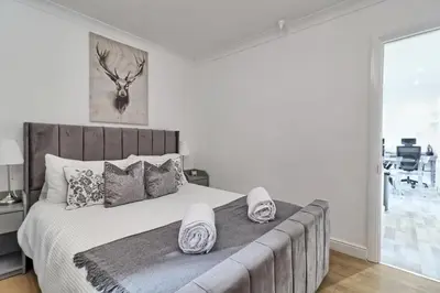 a bedroom with a large bed with slippers on it at Lavish Rayleigh Apartment - LMV Property in Rayleigh