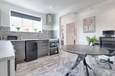 a kitchen with a table and chairs in it at Lavish Rayleigh Apartment - LMV Property in Rayleigh