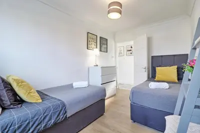 a bedroom with two beds and a dresser at Lavish Rayleigh Apartment - LMV Property in Rayleigh