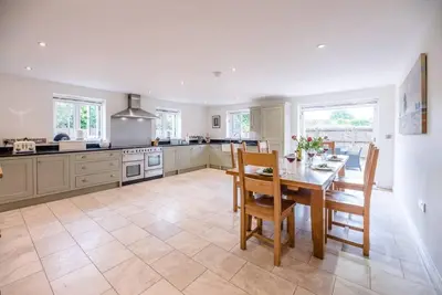 a large kitchen with a table and chairs in it at Foxglove House, Aldeburgh in Aldeburgh