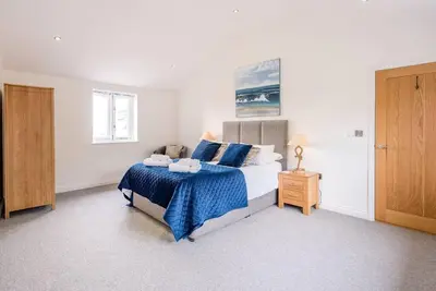 a bedroom with a bed with a blue blanket at Foxglove House, Aldeburgh in Aldeburgh