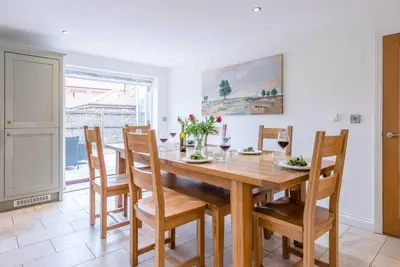 a dining room with a wooden table and chairs at Foxglove House, Aldeburgh in Aldeburgh