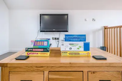 a desk with books and a tv on top of it at Foxglove House, Aldeburgh in Aldeburgh