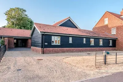 a black house with a red brick building at Foxglove House, Aldeburgh in Aldeburgh