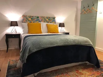 a bedroom with a large bed with yellow pillows at Sunrise Studio in Colchester
