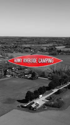 a red and white sign flying over a field at Henny Riverside Glamping in Sudbury