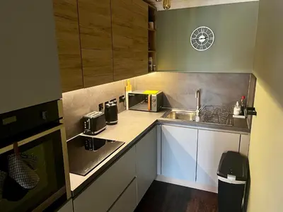 a small kitchen with a sink and a microwave at Comfy, modern one bed apartment in Leiston