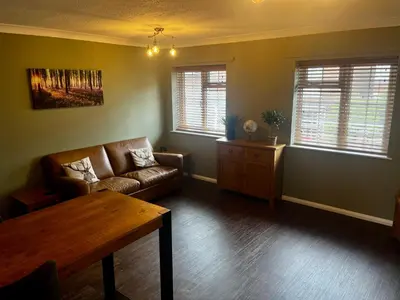 a living room with a couch and a table at Comfy, modern one bed apartment in Leiston