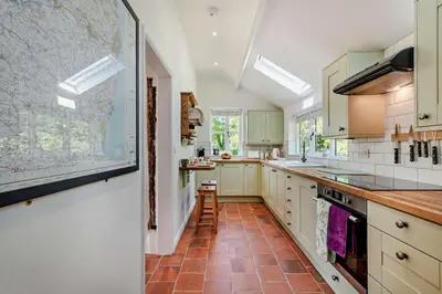 a kitchen with white cabinets and a map on the wall at 2 Bed in Ilketshall St. Margaret oc-w27520 in Rumburgh
