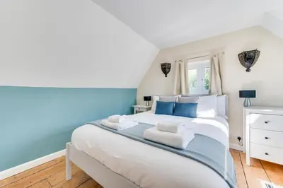 a bedroom with a large white bed with blue accents at 2 Bed in Sweffling oc-whcs in Rendham