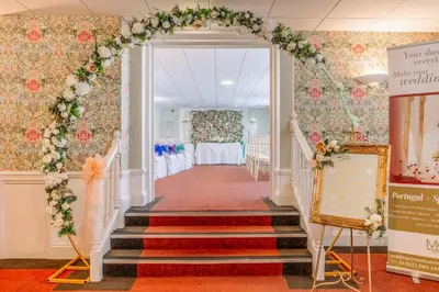 an aisle at a wedding with an arch and flowers at Muthu Westcliff Hotel (Near London Southend Airport) in Southend-on-Sea
