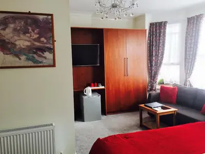 a living room with a couch and a tv at Ilfracombe House Hotel - near Cliffs Pavilion in Southend-on-Sea