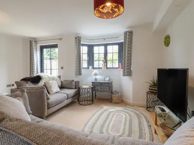 a living room with a couch and a tv at 9 Oaks Court in Leiston