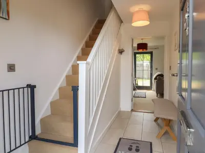 a hallway with stairs leading up to a house at 9 Oaks Court in Leiston
