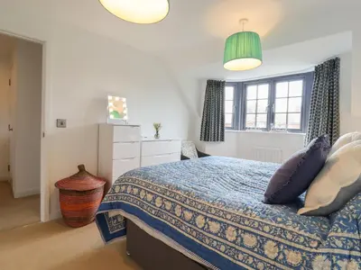 a bedroom with a bed with a blue comforter at 9 Oaks Court in Leiston