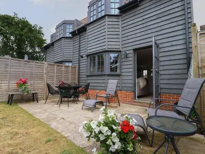 a patio with chairs and tables in front of a house at 9 Oaks Court in Leiston
