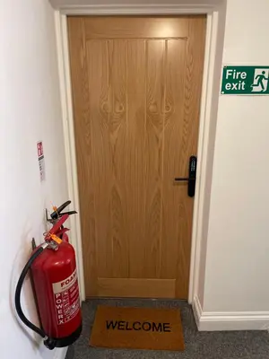 a fire hydrant in front of a wooden door at Entire Apartment boutique king size bed near Town Centre in Colchester