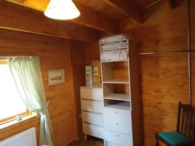 a room with wooden walls and a closet with shelves at Bishy Barnabees country lodge with hot tub in Swaffham