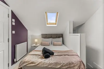 a bedroom with a large bed in a attic at The Suffolk Gem - Games Room in Ipswich