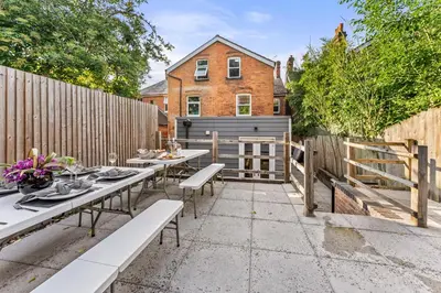 a patio with two tables and a fence at The Suffolk Gem - Games Room in Ipswich