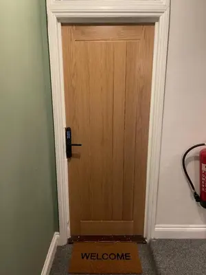 a wooden door with a welcome sign in front of it at Cosy entire apartment super king bed near town center in Colchester