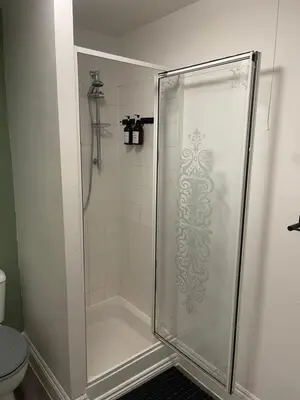 a shower with a glass shower stall with a toilet at Cosy entire apartment super king bed near town center in Colchester