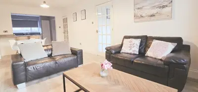 a living room with two leather couches and a coffee table at Grace's Place in Ely in Ely