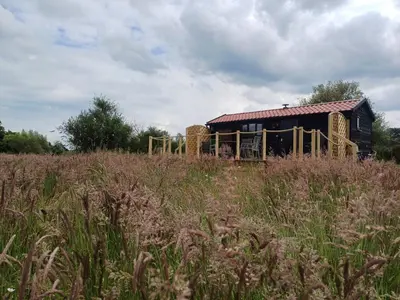 a barn with bales of hay in a field at The Cabin in Pakenham