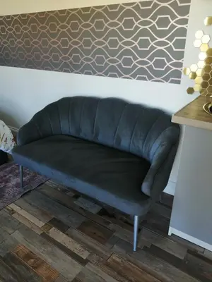 a black leather couch in a room with a wall at The Cabin in Pakenham