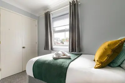 a bedroom with a bed with a towel on it at Chelmsford Reach 3 bed house near centre,free parking, Wi-Fi, table football in Chelmsford