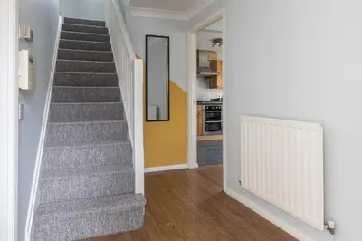 a staircase in a home with a yellow wall at Chelmsford Reach 3 bed house near centre,free parking, Wi-Fi, table football in Chelmsford