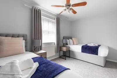 a bedroom with two beds and a ceiling fan at Chelmsford Reach 3 bed house near centre,free parking, Wi-Fi, table football in Chelmsford
