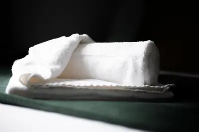 a stack of white towels sitting on a table at Chelmsford Reach 3 bed house near centre,free parking, Wi-Fi, table football in Chelmsford