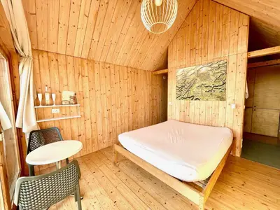a sauna with a bed and a table and chairs at Lushna 10 Classic Suite at Lee Wick Farm Cottages & Glamping in Clacton-on-Sea
