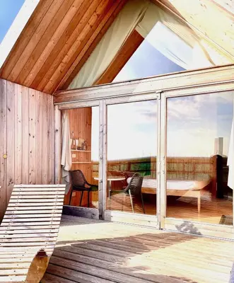 a conservatory with a large window and a table at Lushna 11 Lux Suite at Lee Wick Farm Cottages & Glamping in Clacton-on-Sea