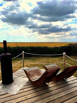 two hammocks sitting on a wooden deck with aburning at Lushna 12 Lux at Lee Wick Farm Cottages & Glamping in Clacton-on-Sea