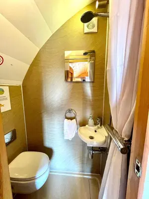 a small bathroom with a toilet and a sink at MegaPod 3 at Lee Wick Farm Cottages & Glamping in Clacton-on-Sea