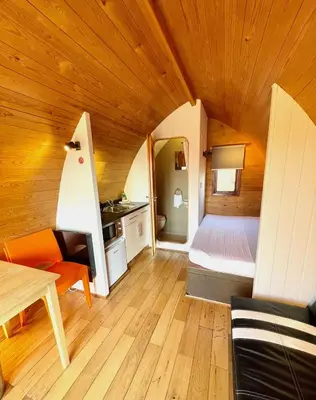 a small room with a bed and a table at MegaPod 2 at Lee Wick Farm Cottages & Glamping in Clacton-on-Sea